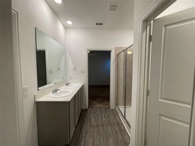 bathroom featuring wood-type flooring, an enclosed shower, and vanity