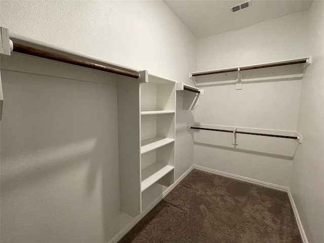 spacious closet featuring dark carpet