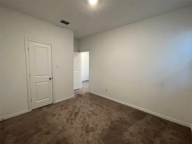 unfurnished bedroom with dark colored carpet