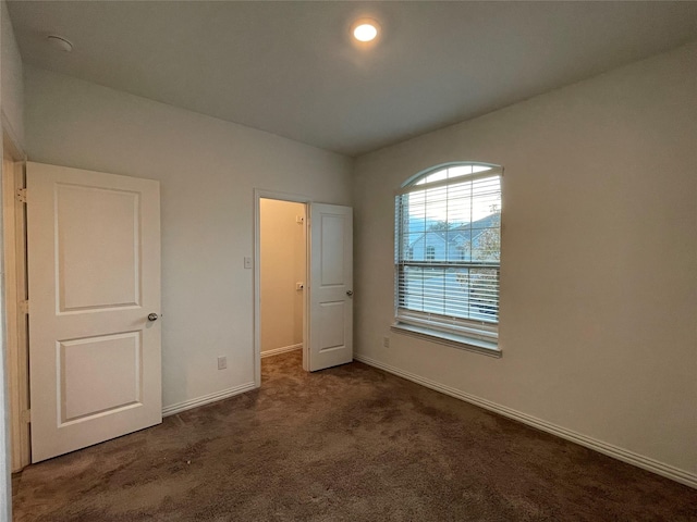 unfurnished bedroom with dark carpet