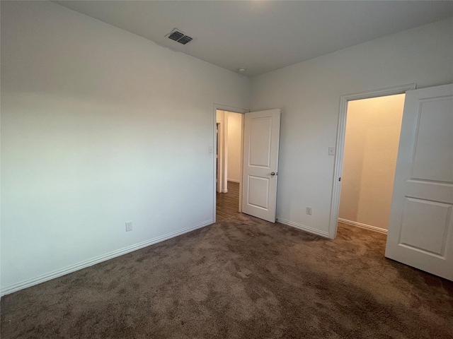 unfurnished bedroom with dark carpet