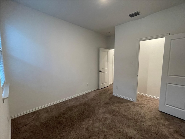 unfurnished bedroom with dark carpet