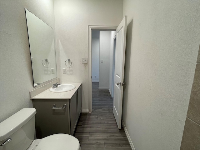 bathroom featuring vanity, toilet, and hardwood / wood-style floors