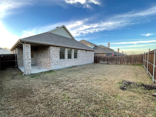 rear view of house featuring a lawn and a patio area