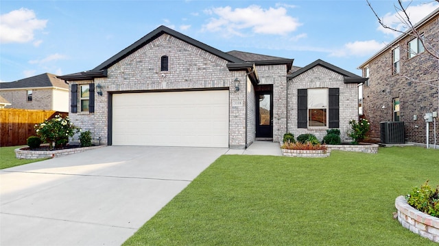 view of front of home featuring central air condition unit, a front lawn, and a garage