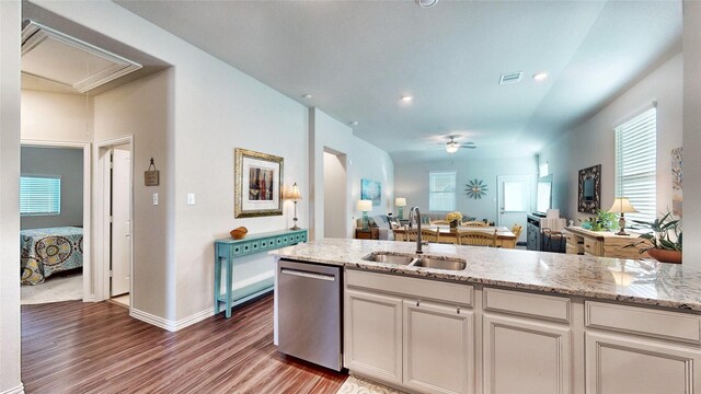 kitchen with dishwasher, sink, hardwood / wood-style flooring, ceiling fan, and light stone counters