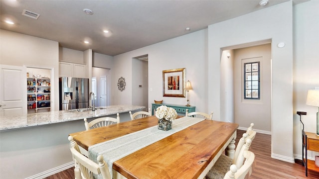 dining area with light hardwood / wood-style floors and sink