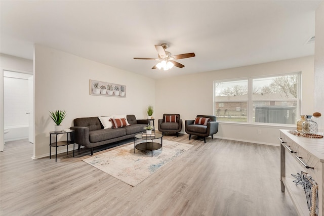 living room with light hardwood / wood-style floors and ceiling fan