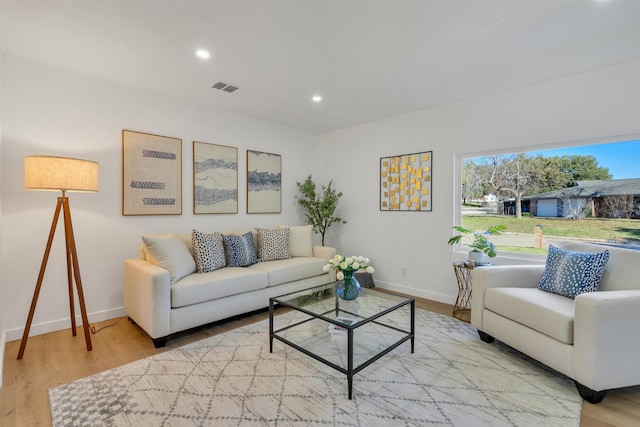 living area with recessed lighting, visible vents, baseboards, and wood finished floors