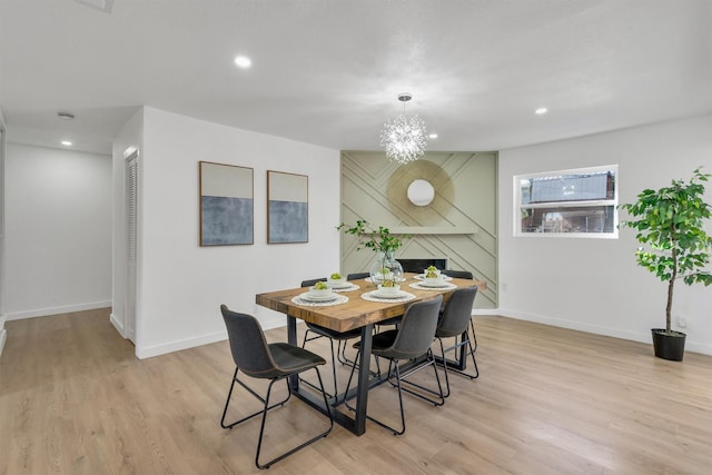 dining space with baseboards, light wood-type flooring, a fireplace, a notable chandelier, and recessed lighting