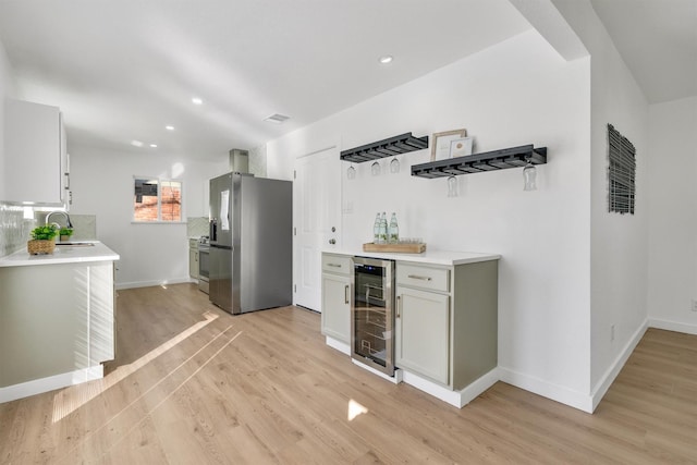 kitchen with wine cooler, stainless steel fridge with ice dispenser, sink, and light hardwood / wood-style flooring