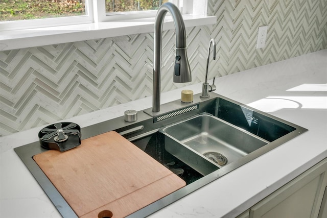 details featuring tasteful backsplash and a sink