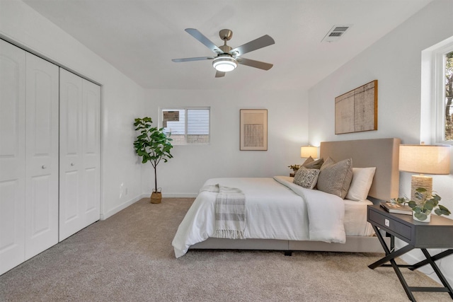 carpeted bedroom with ceiling fan and a closet