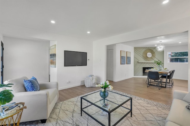 living room with recessed lighting, a fireplace, and wood finished floors