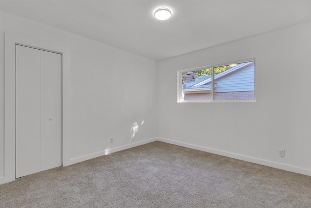 unfurnished bedroom featuring carpet floors, a closet, and baseboards