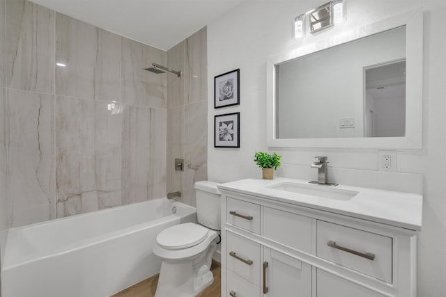 full bathroom featuring tasteful backsplash, tiled shower / bath, toilet, vanity, and hardwood / wood-style flooring