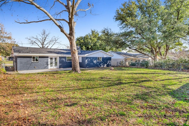 exterior space featuring a yard, french doors, fence, and brick siding