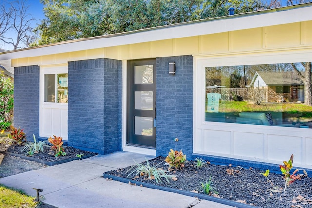 doorway to property featuring brick siding