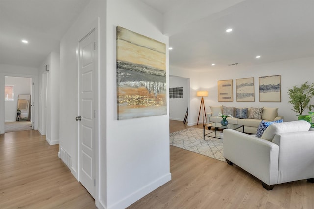 living area featuring baseboards, recessed lighting, visible vents, and light wood-style floors