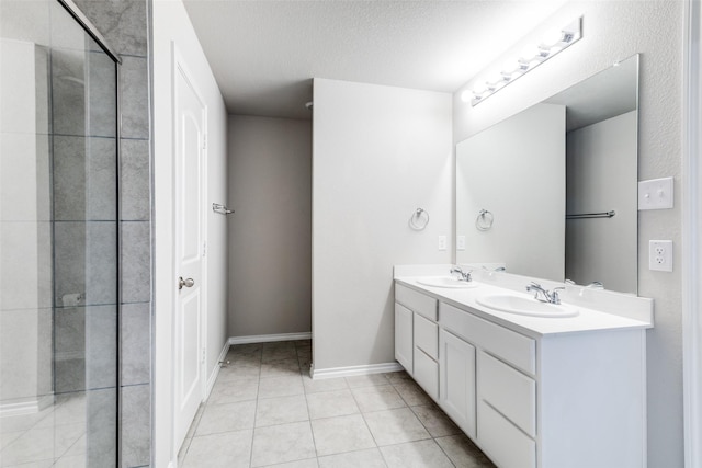 bathroom with tile patterned flooring, a textured ceiling, and vanity