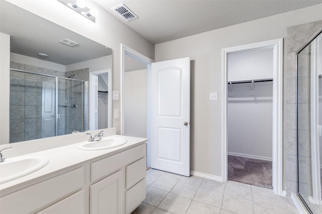 bathroom with tile patterned flooring, vanity, and an enclosed shower