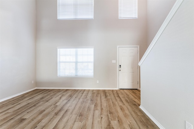 entrance foyer with light hardwood / wood-style floors and a high ceiling