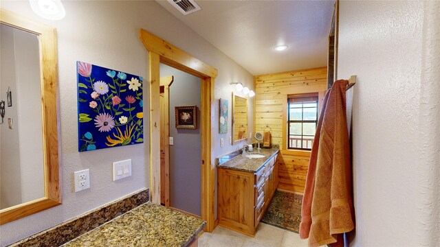 bathroom featuring vanity and wooden walls