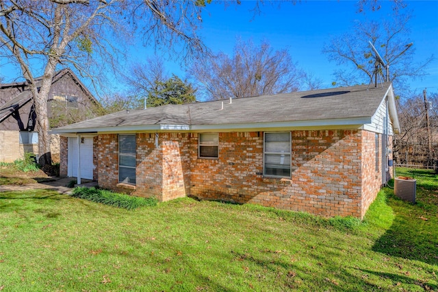 back of house featuring central AC unit and a yard