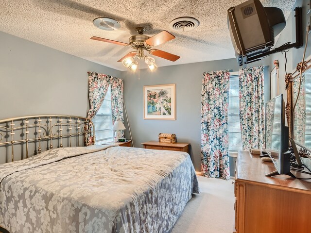 bedroom featuring ceiling fan, carpet floors, and a textured ceiling