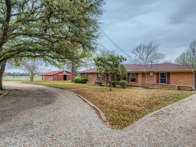 single story home with a front lawn and an outdoor structure