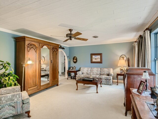 carpeted living room featuring ceiling fan and ornamental molding