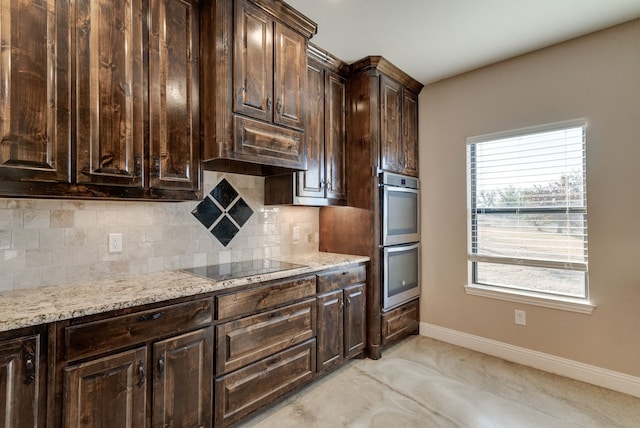 kitchen with backsplash, black electric stovetop, stainless steel double oven, light stone counters, and dark brown cabinetry