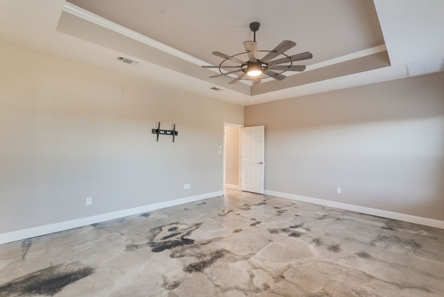 unfurnished room featuring a raised ceiling, ceiling fan, and ornamental molding