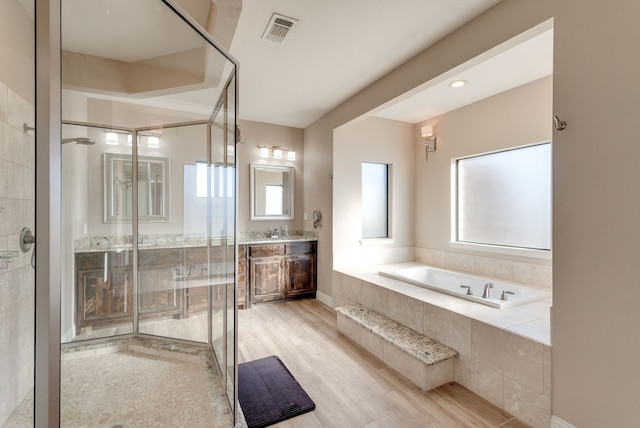 bathroom with separate shower and tub, vanity, and wood-type flooring