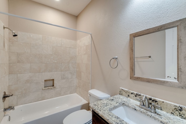 full bathroom with vanity, tiled shower / bath combo, and toilet