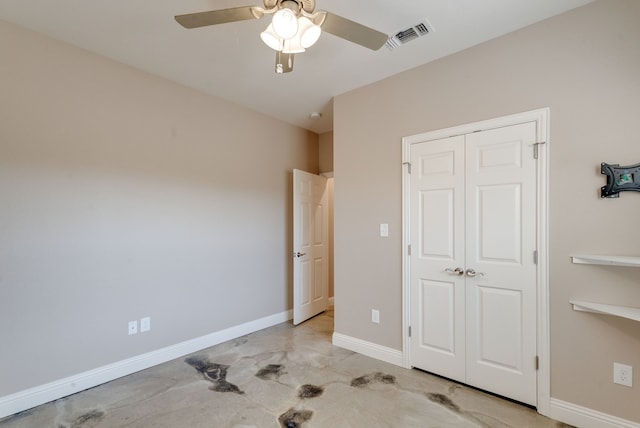 unfurnished bedroom with ceiling fan and a closet