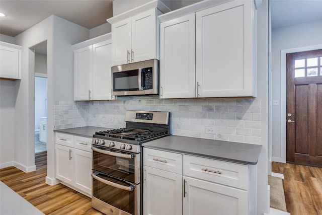 kitchen with light hardwood / wood-style flooring, stainless steel appliances, and white cabinets