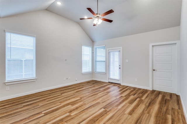 unfurnished room with ceiling fan, lofted ceiling, and light wood-type flooring