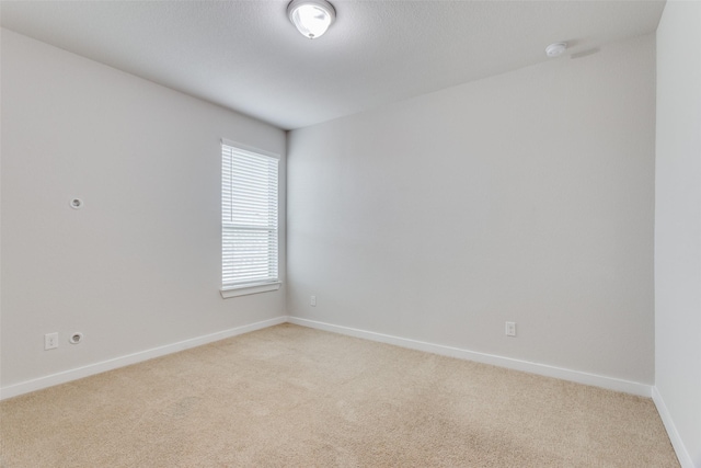 spare room with light carpet and a textured ceiling