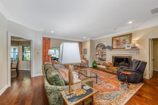 living room with built in features, dark wood-type flooring, and ornamental molding