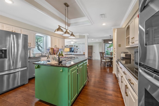 kitchen featuring green cabinets, white cabinetry, appliances with stainless steel finishes, a healthy amount of sunlight, and a kitchen island