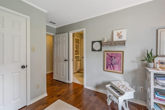 sitting room featuring crown molding and dark wood-type flooring