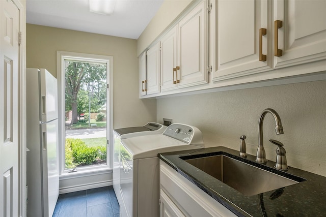 laundry area with cabinets, washing machine and dryer, sink, and a wealth of natural light