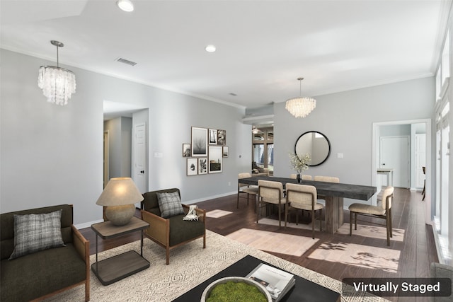 living room with hardwood / wood-style floors, ornamental molding, and an inviting chandelier