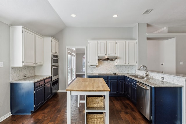 kitchen with decorative backsplash, stainless steel appliances, blue cabinets, sink, and white cabinetry