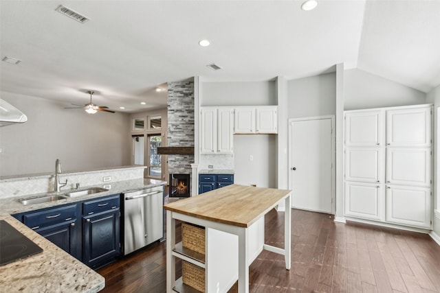 kitchen featuring backsplash, stainless steel dishwasher, blue cabinets, sink, and white cabinetry