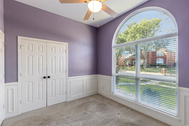 unfurnished bedroom with light carpet, a closet, and ceiling fan