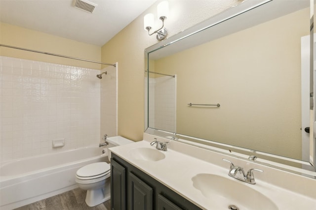 full bathroom with vanity, toilet, washtub / shower combination, and hardwood / wood-style flooring