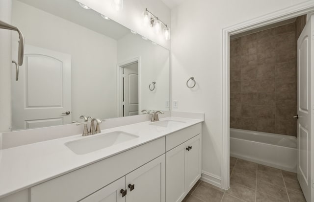 full bathroom featuring double vanity, baseboards, a sink, and tile patterned floors