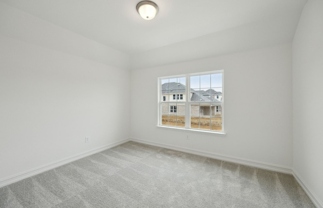 spare room with baseboards and carpet flooring